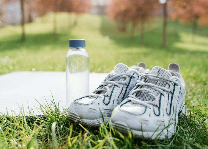 Close-up of athletic shoes and a bottle of water.