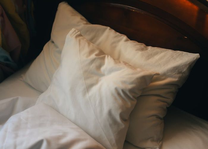 Person stretching near a window with warm morning light.